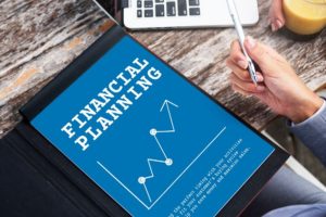 A person reviewing an annual financial plan on a digital tablet, with charts and a pen in hand, symbolizing organized budgeting and long-term financial strategy.